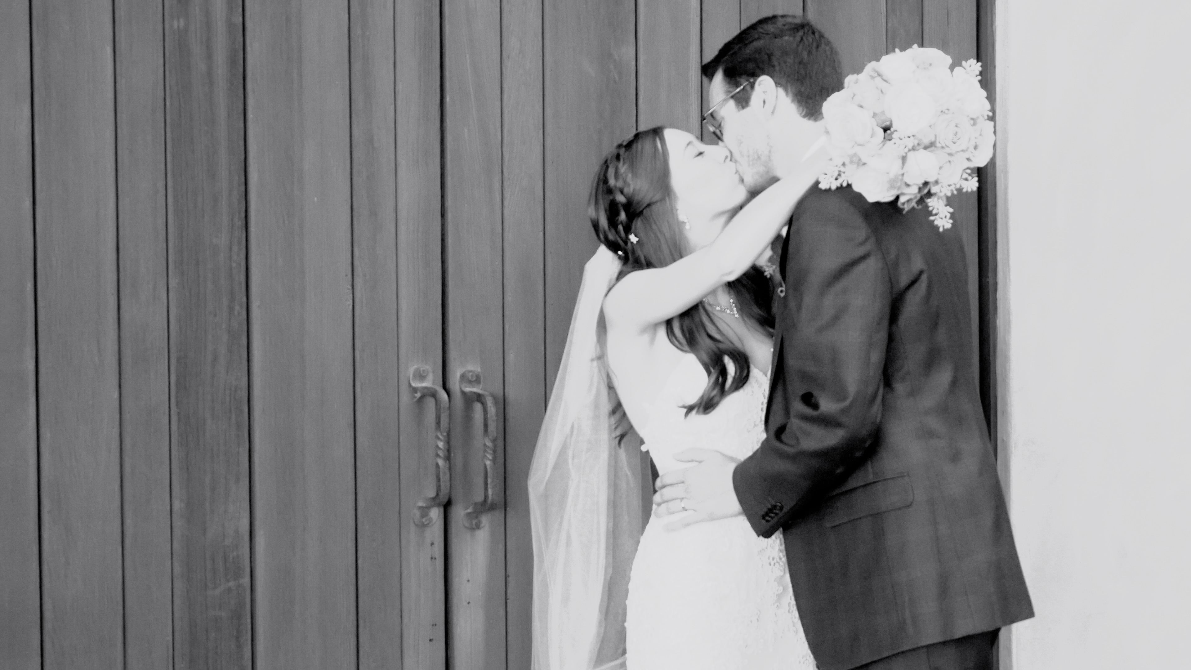 couple kissing in front of winery doors in napa valley