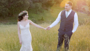 Mendocino Wedding Video with couple in field holding hands at sunset 