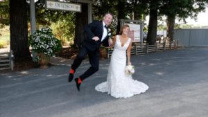 excited groom with red socks and bride at first look